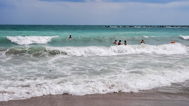 Plajă românească cu apă rece și turiști în apă