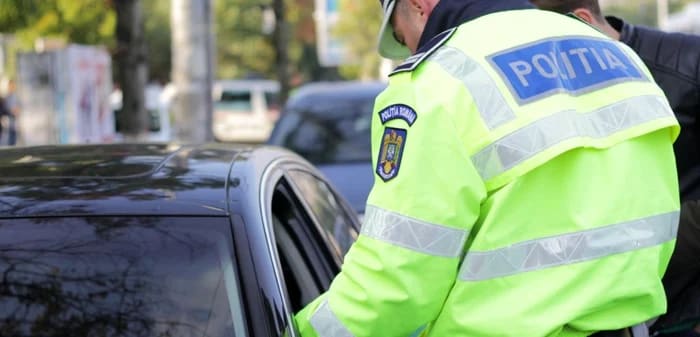 Polițist în uniformă cu ordin de protecție în mână, stradă din Făgăraș Polițist în uniformă cu ordin de protecție în mână, stradă din Făgăraș