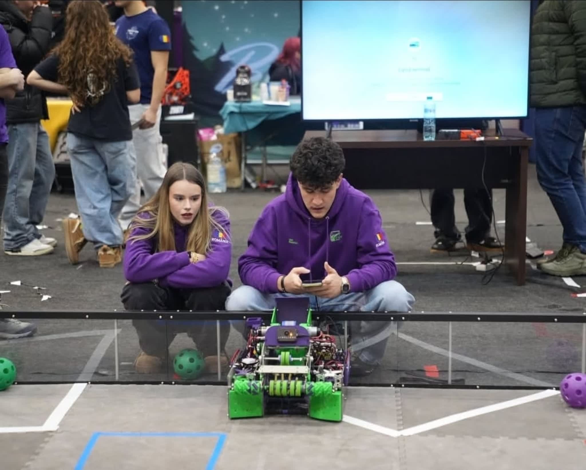 Tineri studenți în laborator de robotică, cu roboți și echipamente tehnologice