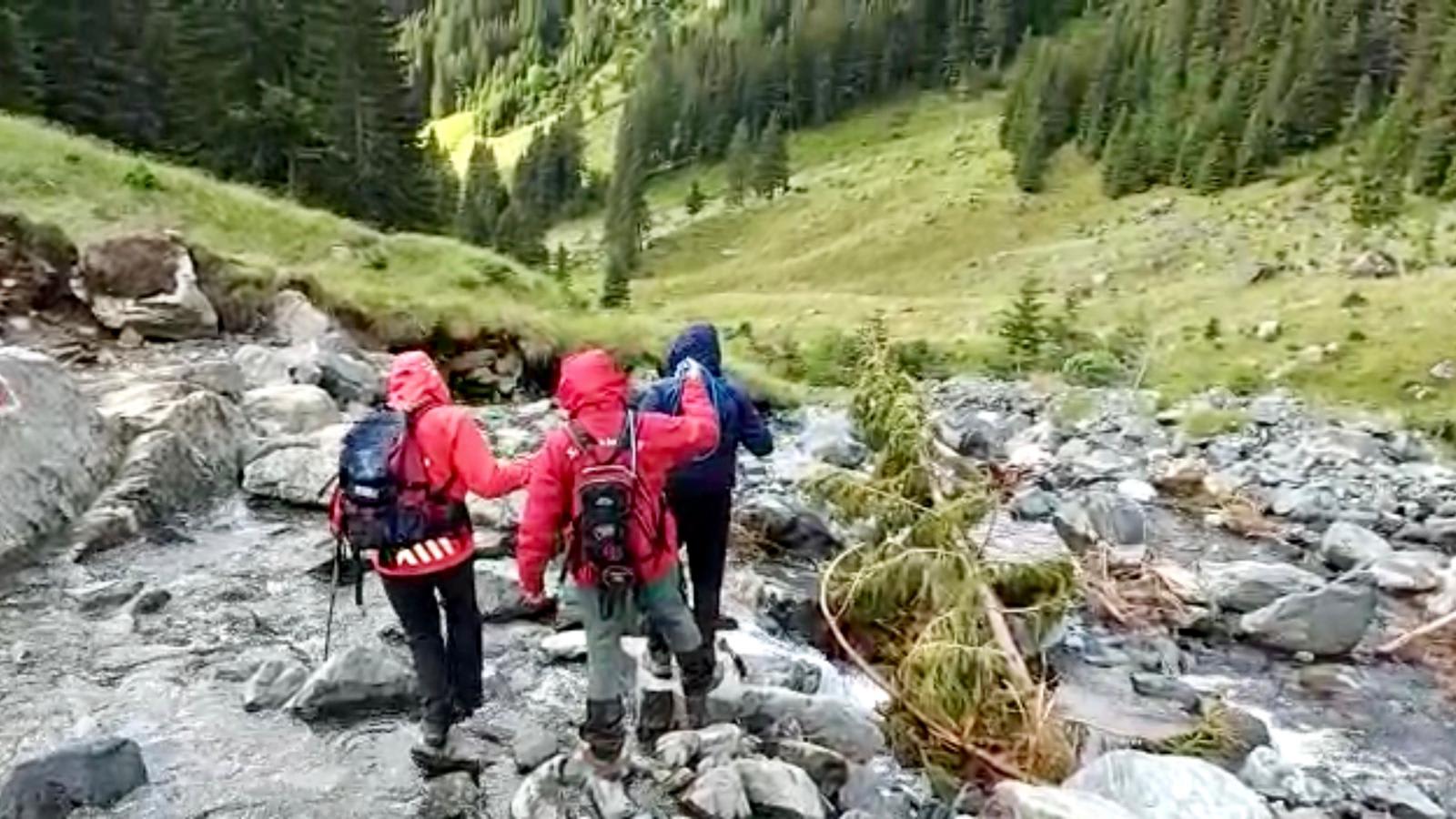 Salvatori montani evacuând persoane din zona afectată de viitură în Munții Făgăraș