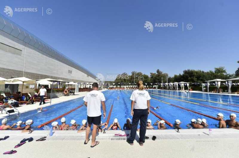 Copii și adulți practicând înot în piscină modernă