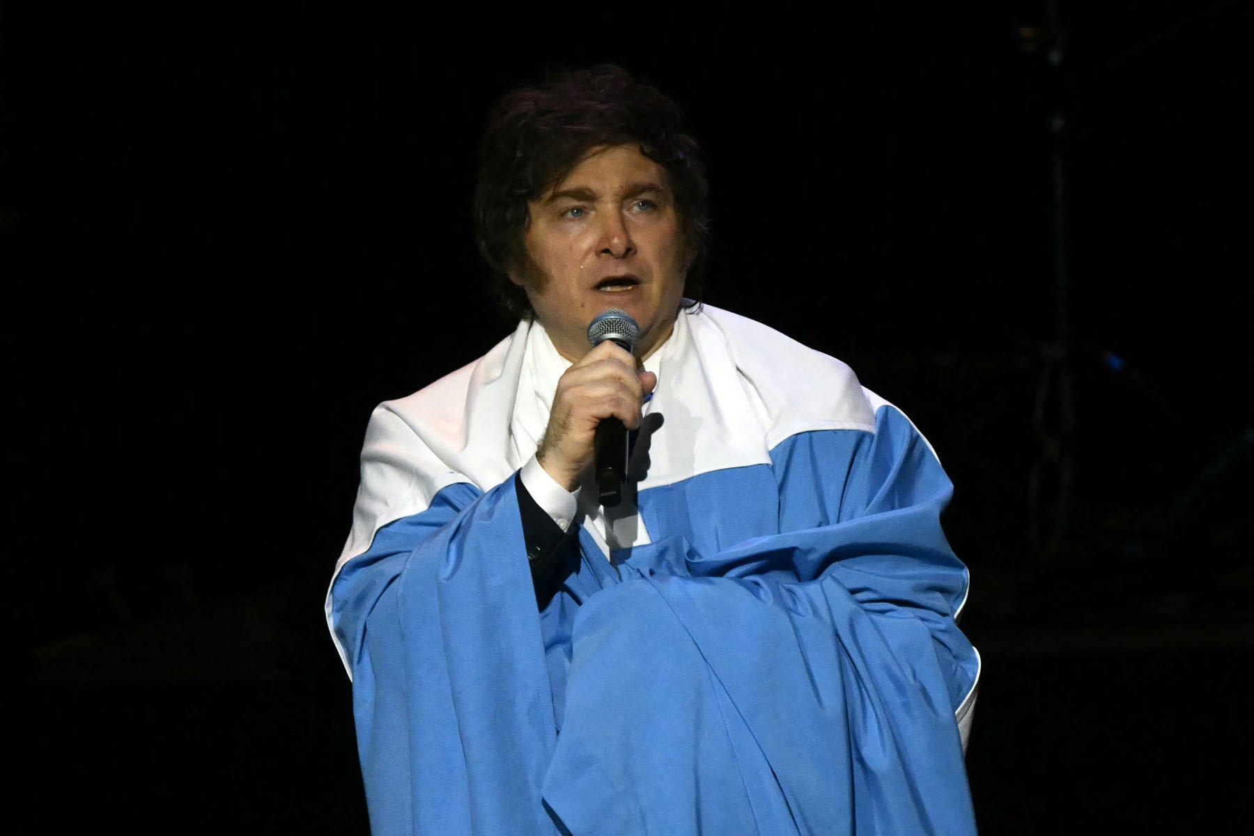 Javier Milei înfășurat în steagul Argentinei, anunțând zi liberă
