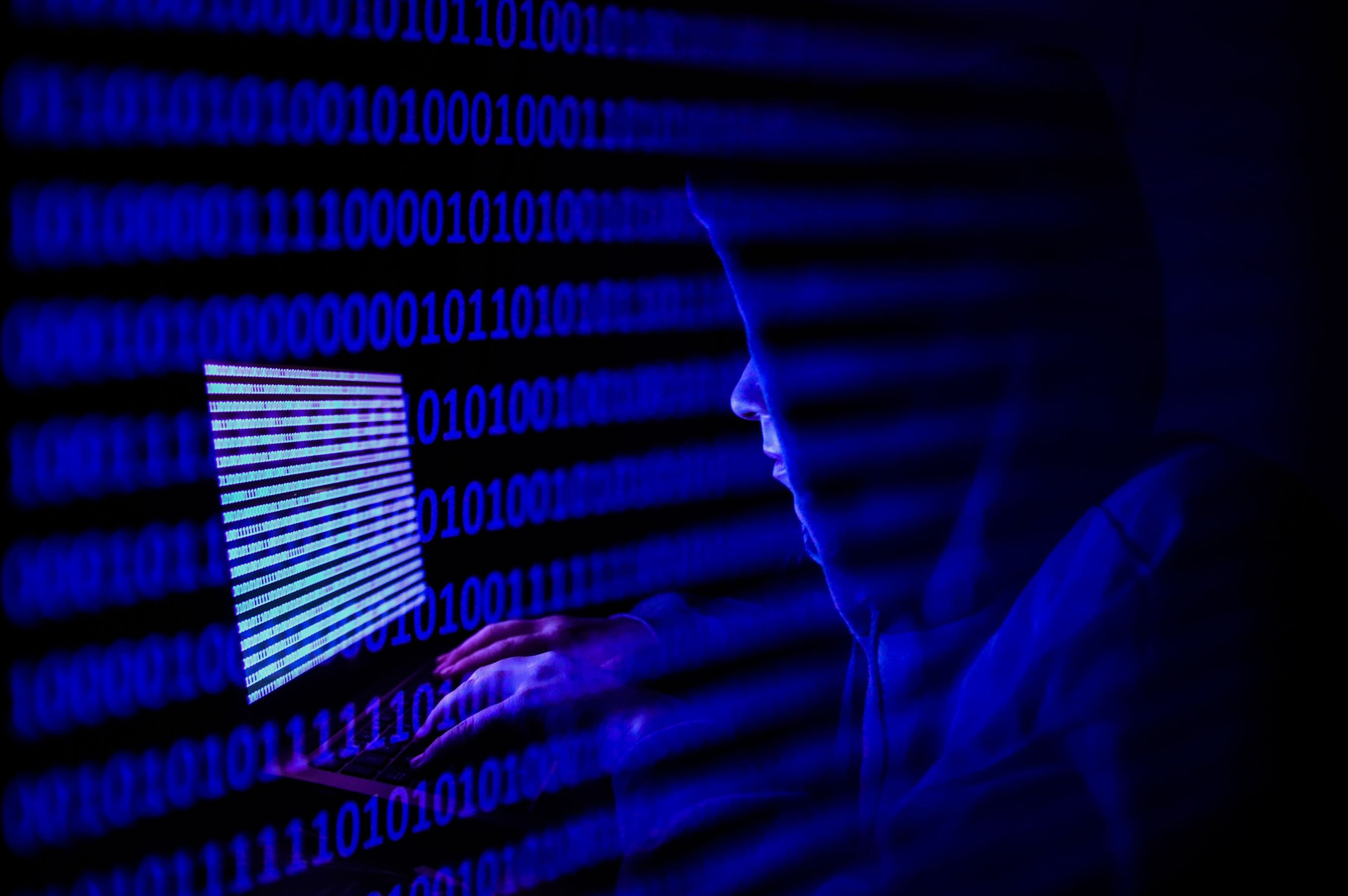 Hacker în fața unui laptop, simbolizând atacul cibernetic asupra sistemelor ANCPI Hacker în fața unui laptop, simbolizând atacul cibernetic asupra sistemelor ANCPI