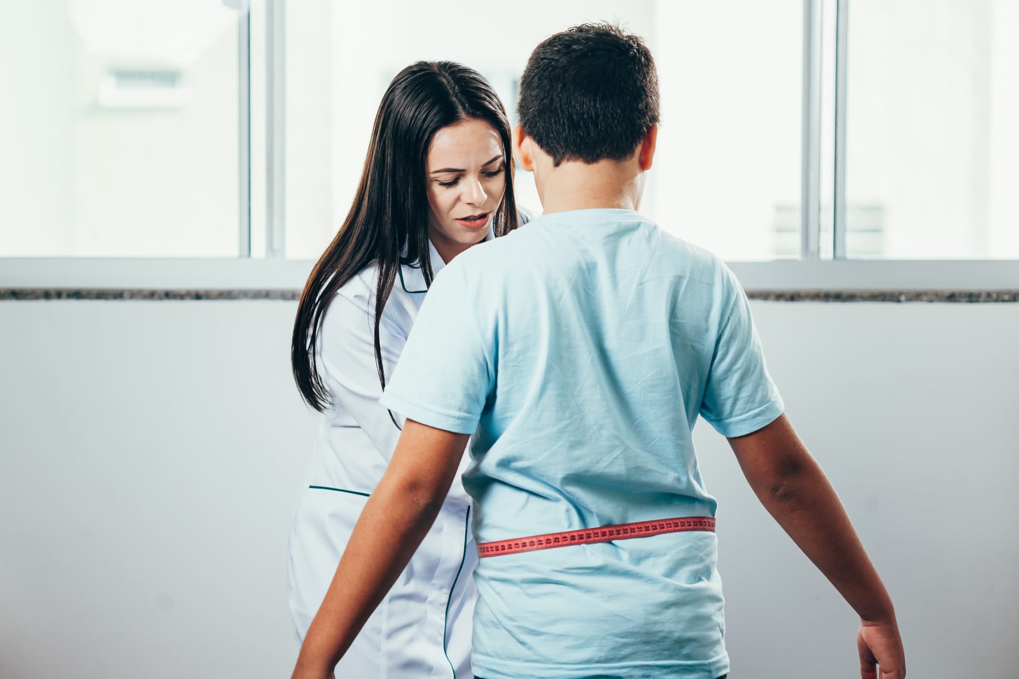 Copil de 12 ani cu analize medicale, medic și părinți în cabinet