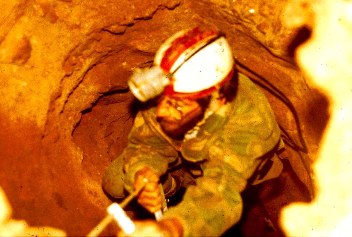 Speolog în explorare în peștera din România, echipament de protecție, galerii întunecate