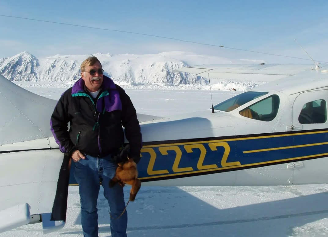 Pilot din Alaska cu avionul în fundal, pachet cu beri în bagaj Pilot din Alaska cu avionul în fundal, pachet cu beri în bagaj