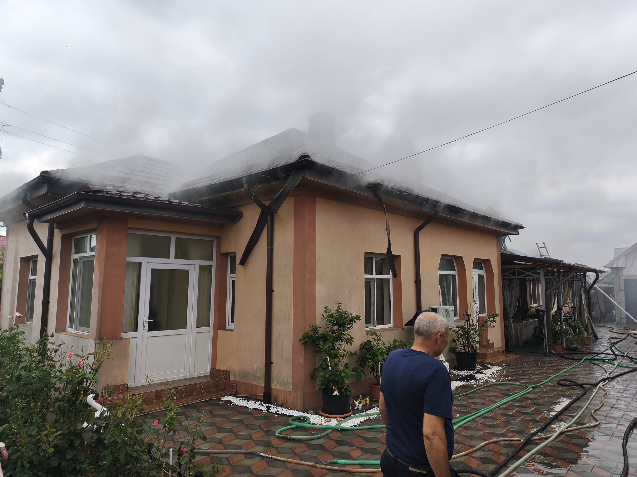 Pompieri stingând incendiu la o casă din Piatra-Olt