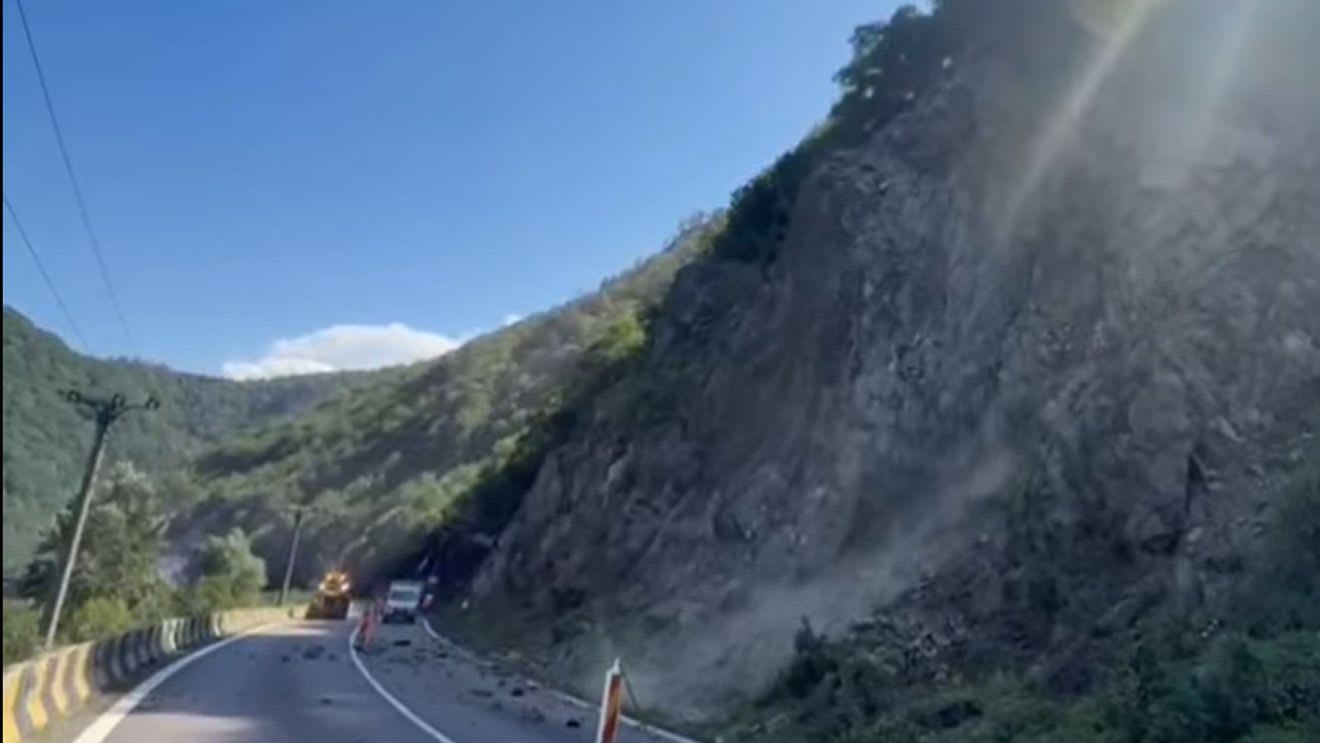 Echipă de muncitori montând plase de protecție pe versant în zona DN7