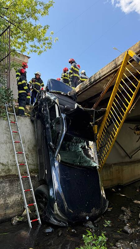 Pompieri extragând o persoană din autoturism în râul Săsar