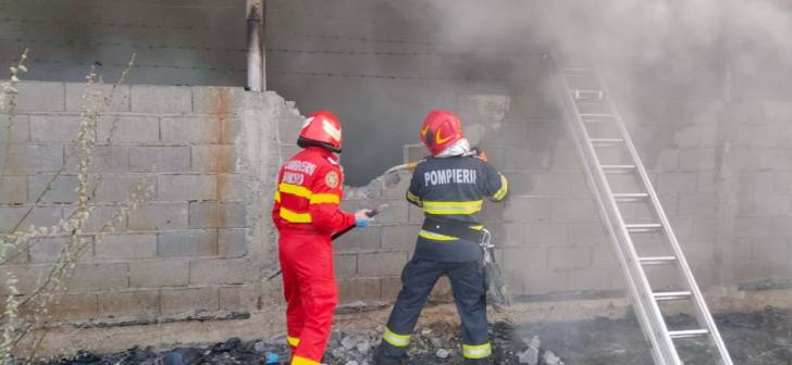 Pompieri în acțiune stingând un incendiu la o casă din Sânmihaiu Român