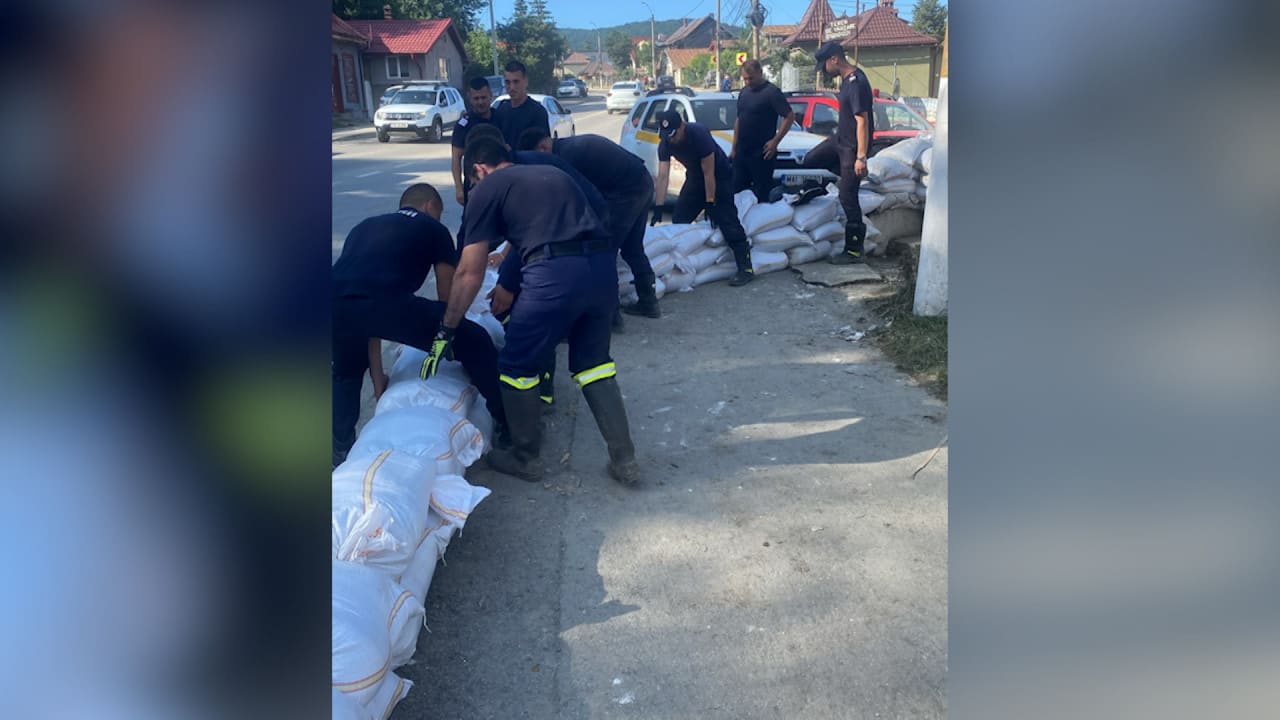 Pompieri români evacuând apă din gospodării inundate în Prahova