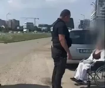 Femeie în scaun cu rotile cerșind pe stradă în București, aproape de mașina de lux a mamei sale