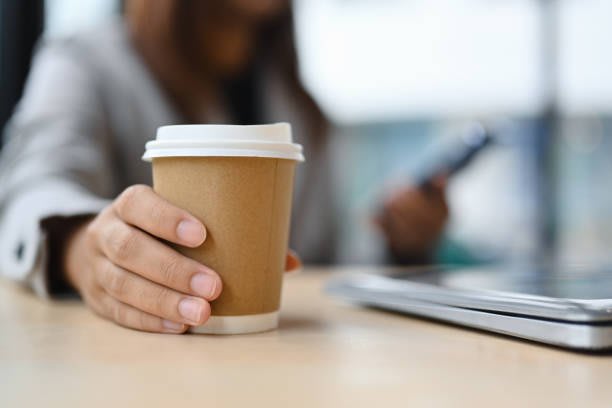 Ceașcă de cafea aburindă pe masă, în bucătărie modernă Ceașcă de cafea aburindă pe masă, în bucătărie modernă
