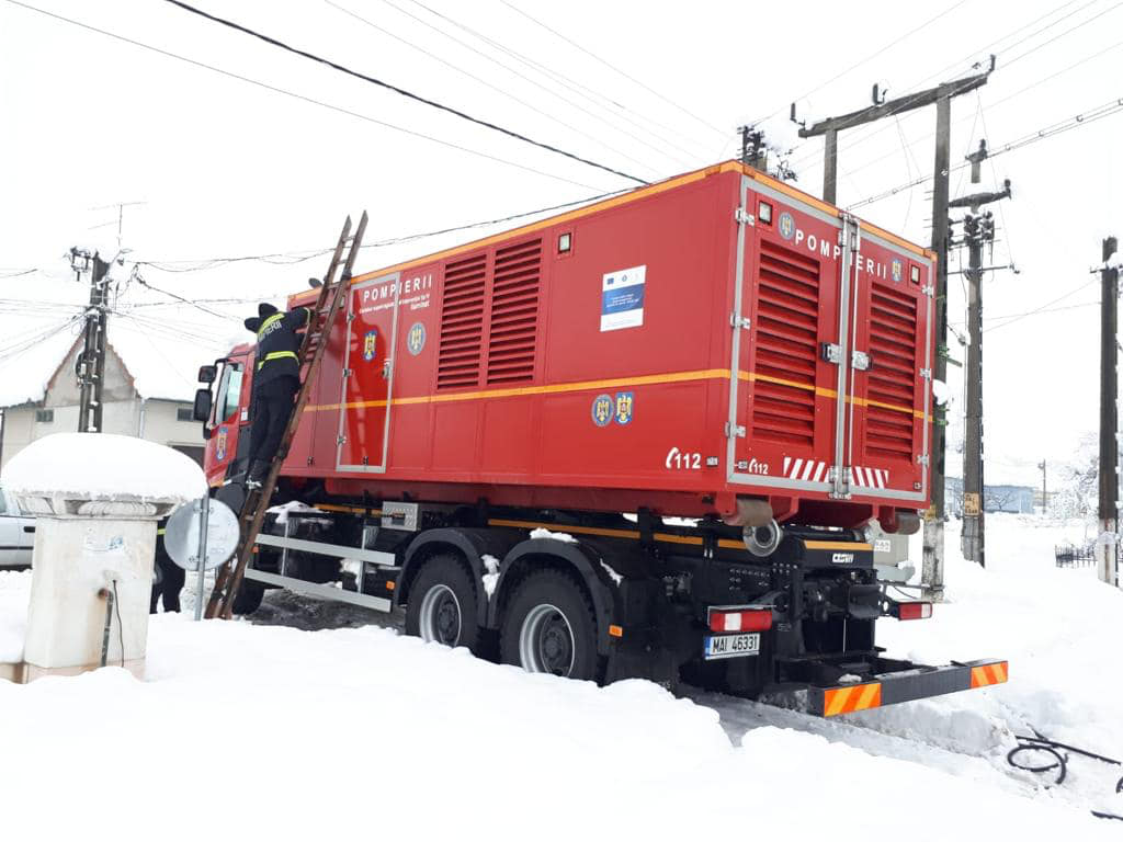Echipă de tehnicieni instalând generator electric în Nădrag