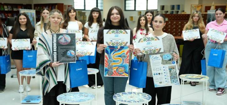 Studenți prezentând lucrarea de mozaic în expoziție