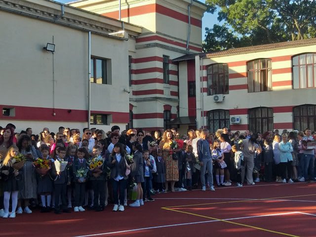Elevi buzoieni în curtea școlii, sărbătorind finalul anilor de studiu