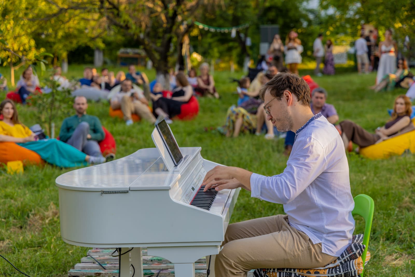 O scenă cu oameni la picnic în natură, muzică live și atmosferă relaxantă