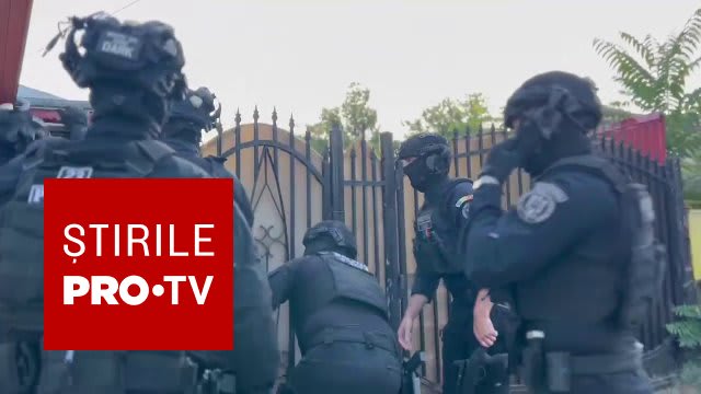 Polițist în acțiune în timpul perchezițiilor la locuințele suspectului din Botoșani