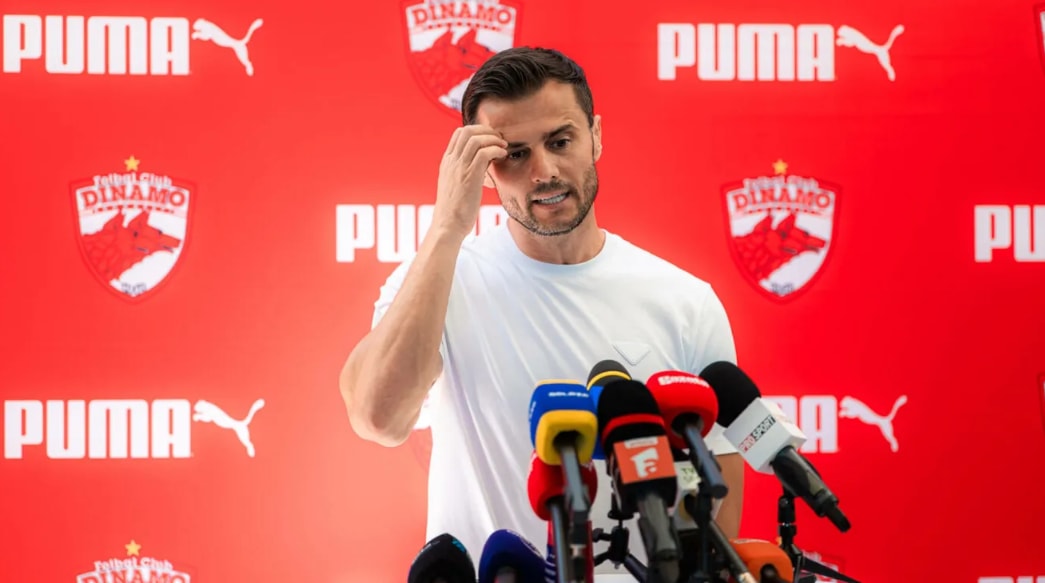 Andrei Nicolescu în conferință de presă, gesticulând, în fața microfonului