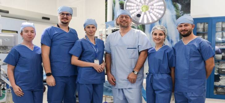 Medici chirurgi ginecologi în sala de operație, utilizând tehnica vNOTES
