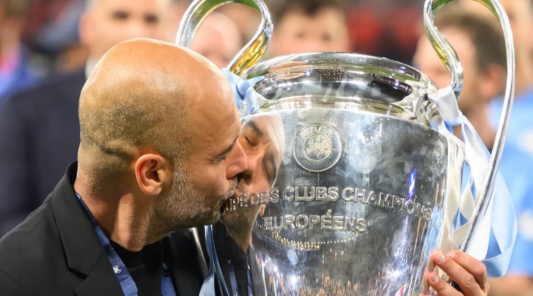Pep Guardiola în fața unui stadion de fotbal, discutând cu oficiali Pep Guardiola în fața unui stadion de fotbal, discutând cu oficiali