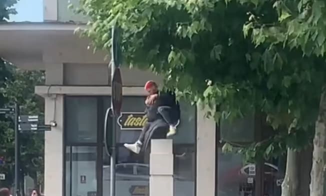 Tânăr pe statuia din Piața Lucian Blaga din Cluj, făcând gesturi obscene