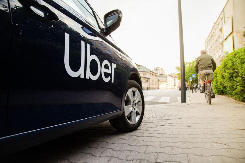 Travis Kalanick în fața unui logo Uber, tehnologie și industrie