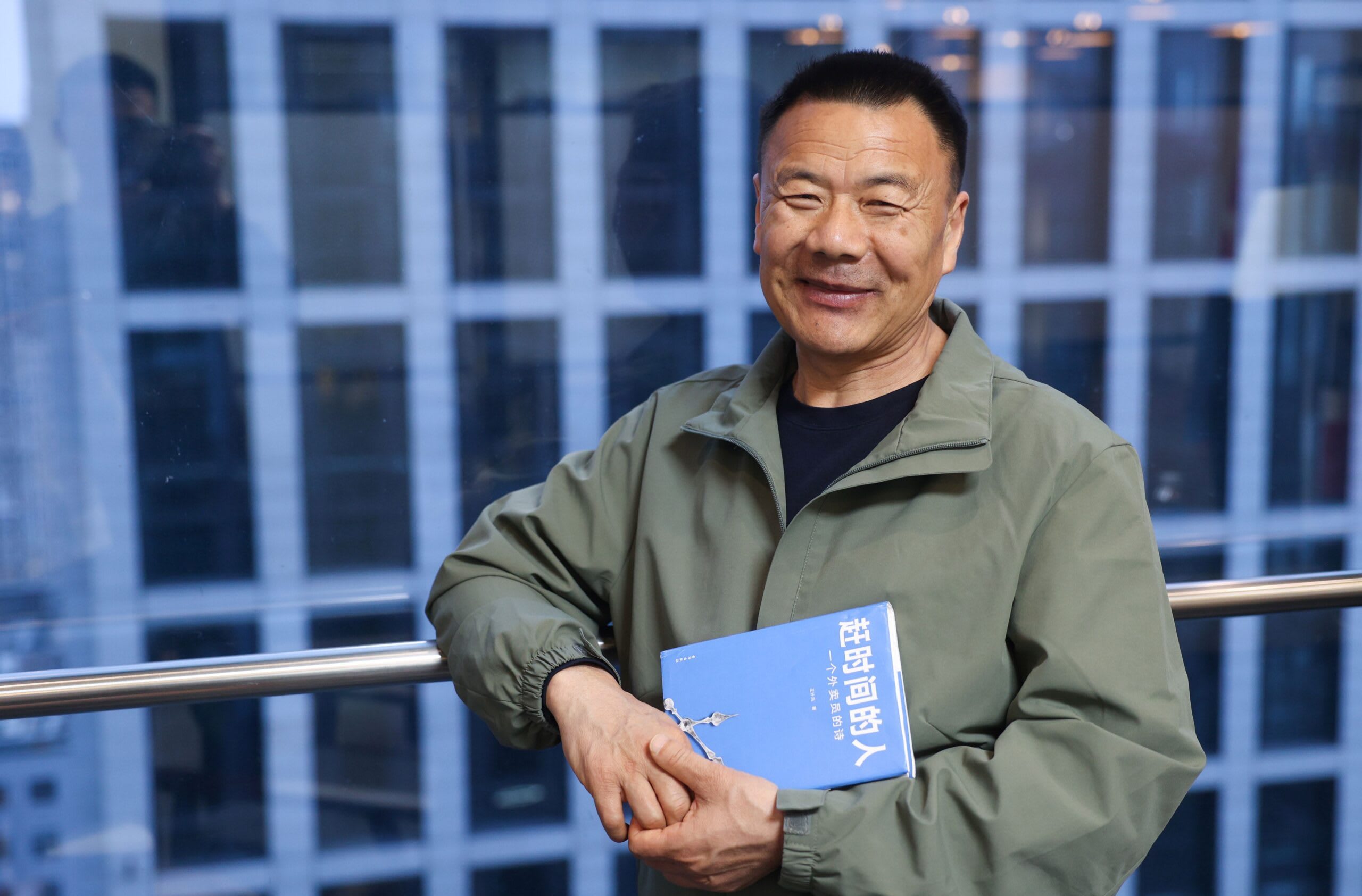 Wang Jibing, livrator de mâncare, ține premiul literar Lu Xun în mână