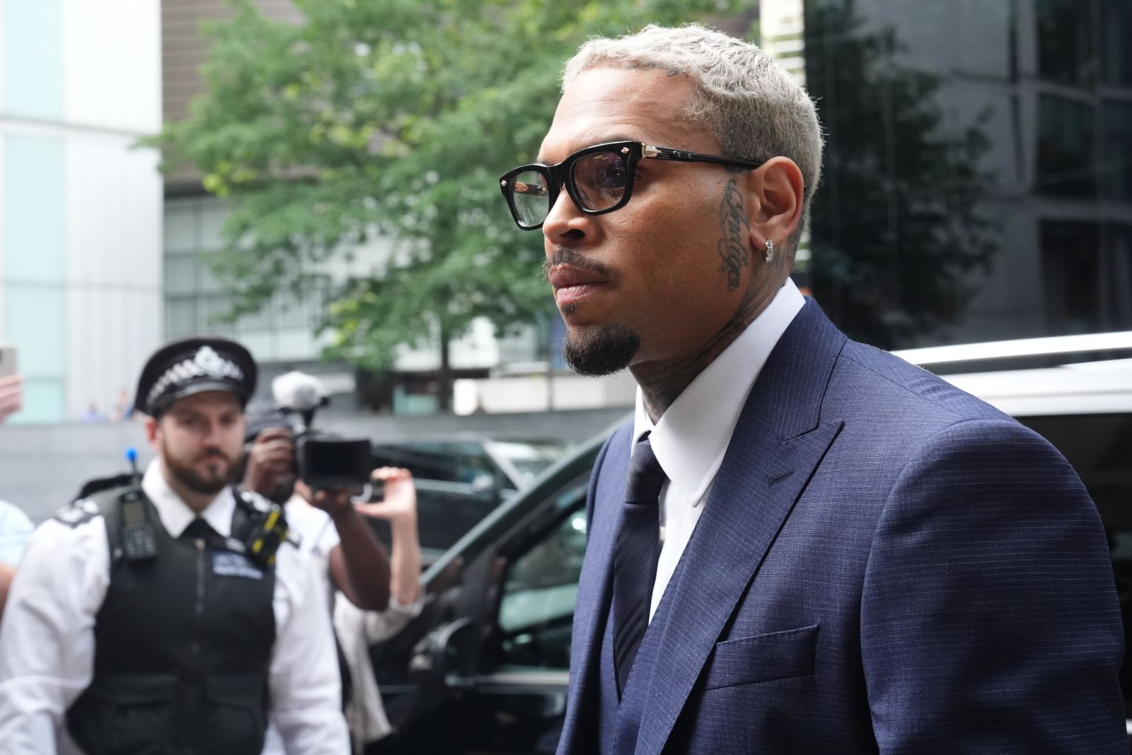Chris Brown în fața tribunalului din Londra, însoțit de avocați