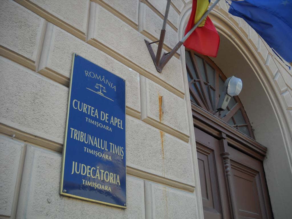 Judecător cu documente în sala de tribunal, România