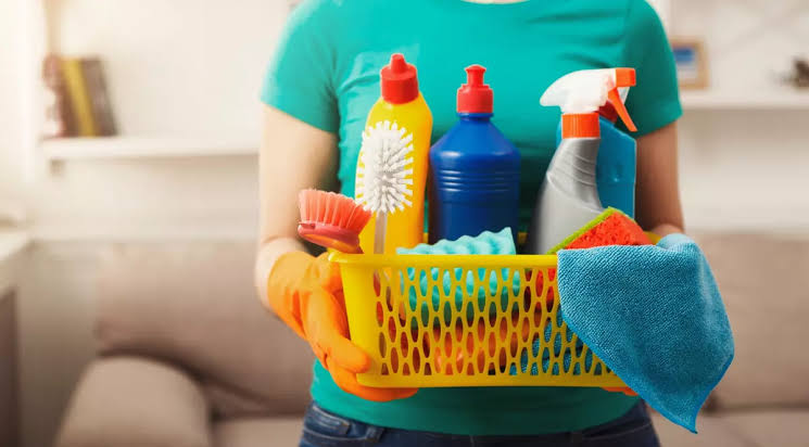 Persoană poartă mănuși și spray de curățenie în casă