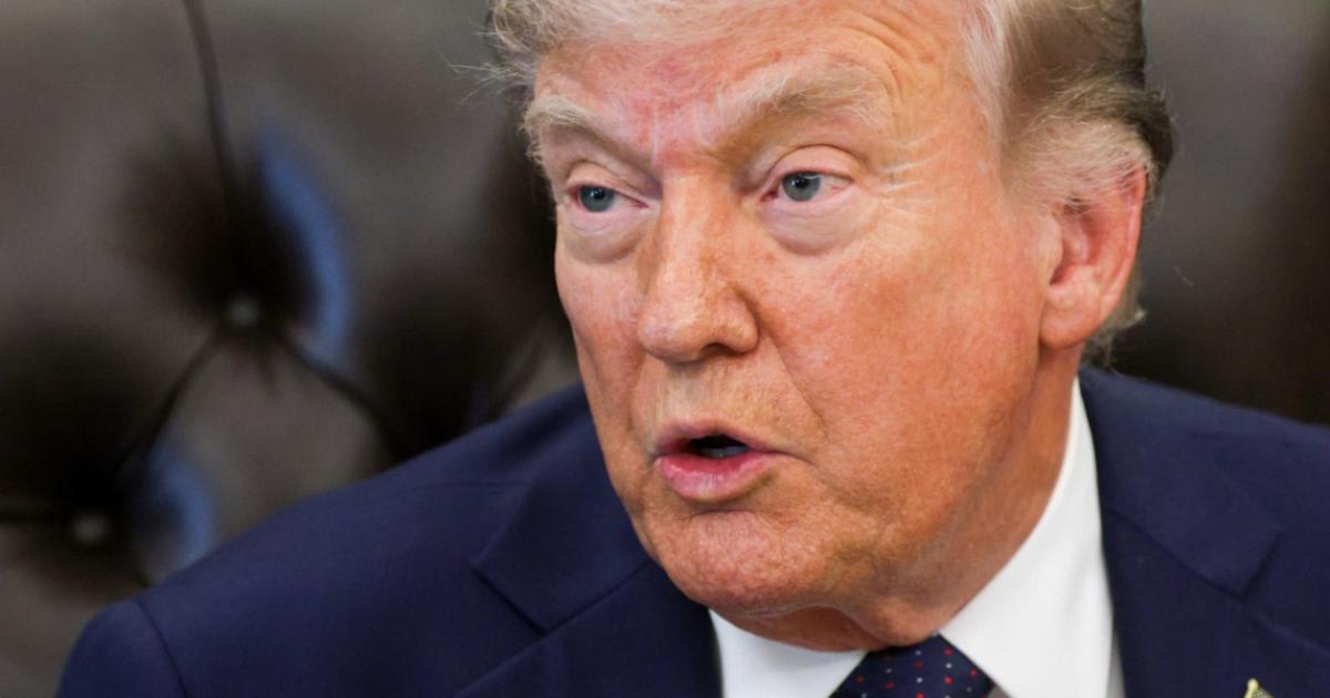Donald Trump în fața microfonului, gesticulând în timpul unei declarații
