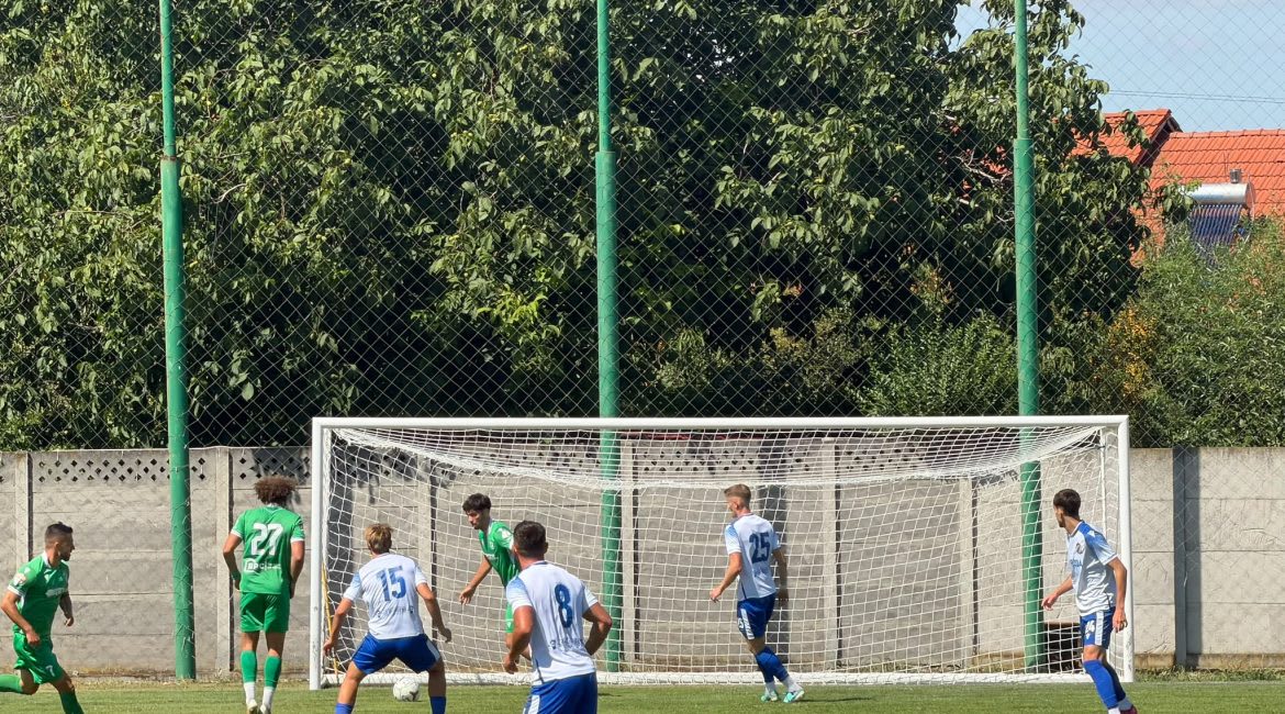 Jucători de fotbal în acțiune pe stadionul Emilian Pavel