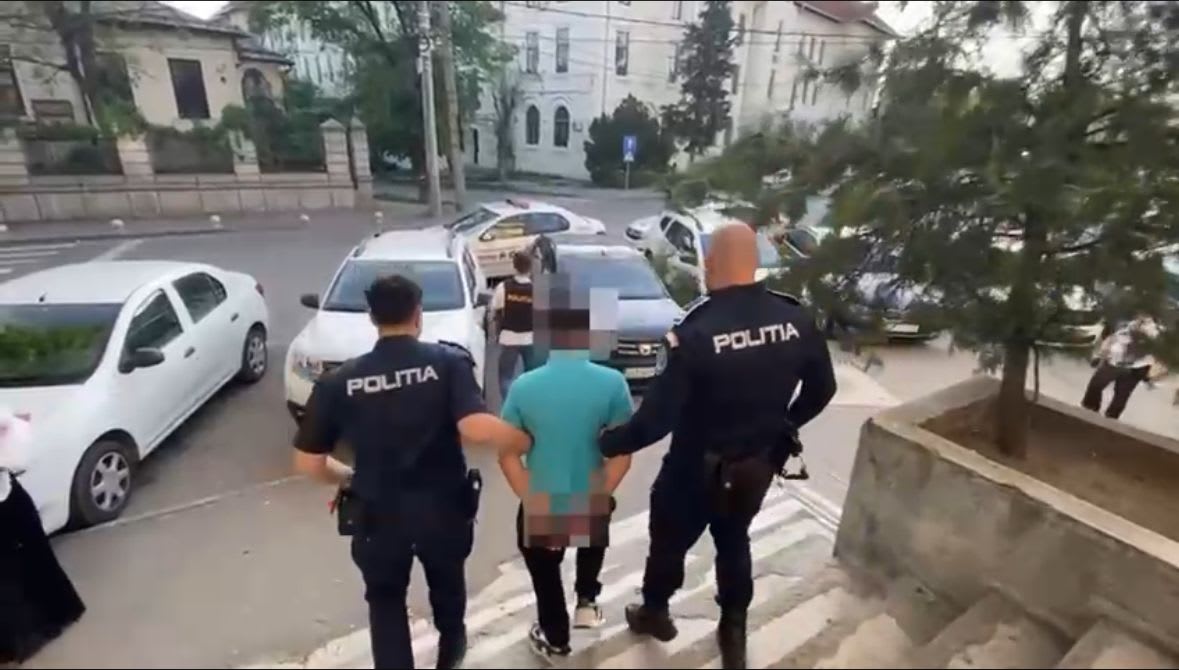 Polițist în uniformă reținând un bărbat în Craiova