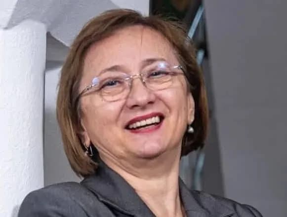 Profesoara Mariana Voicu în sala de clasă, zâmbind elevilor Profesoara Mariana Voicu în sala de clasă, zâmbind elevilor