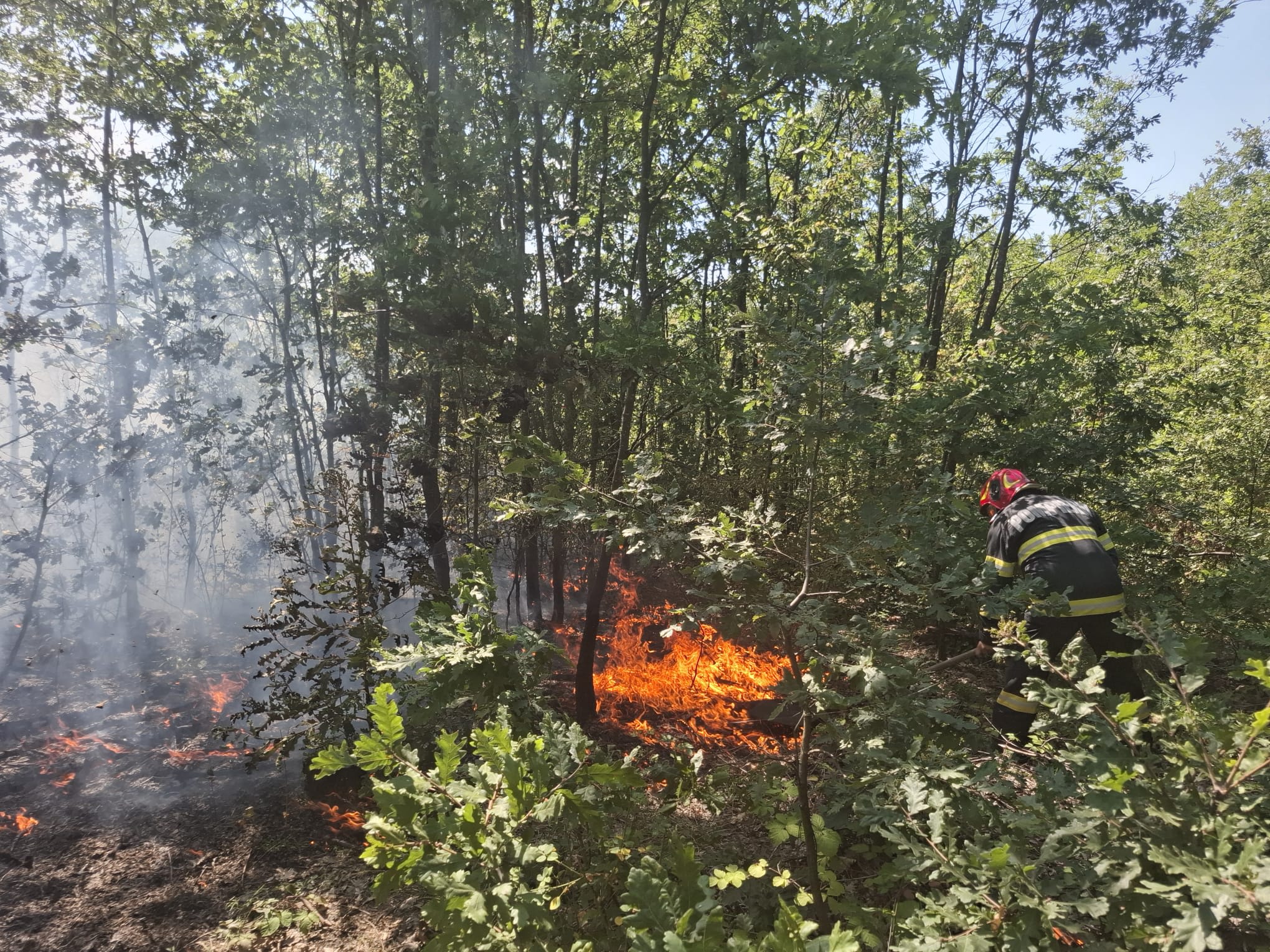 Pompieri români în acțiune cu elicopterul sprijinind stingerea incendiului de vegetație