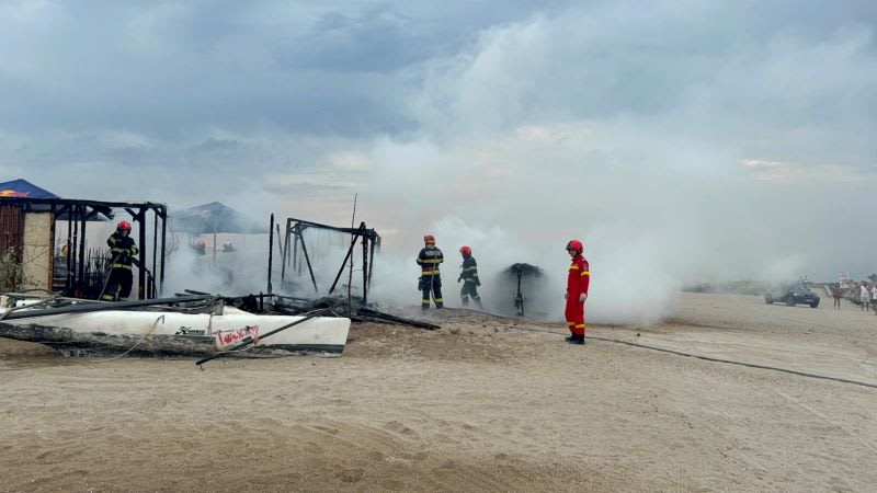 Pompieri în acțiune stingând un incendiu la plaja Zoom Beach