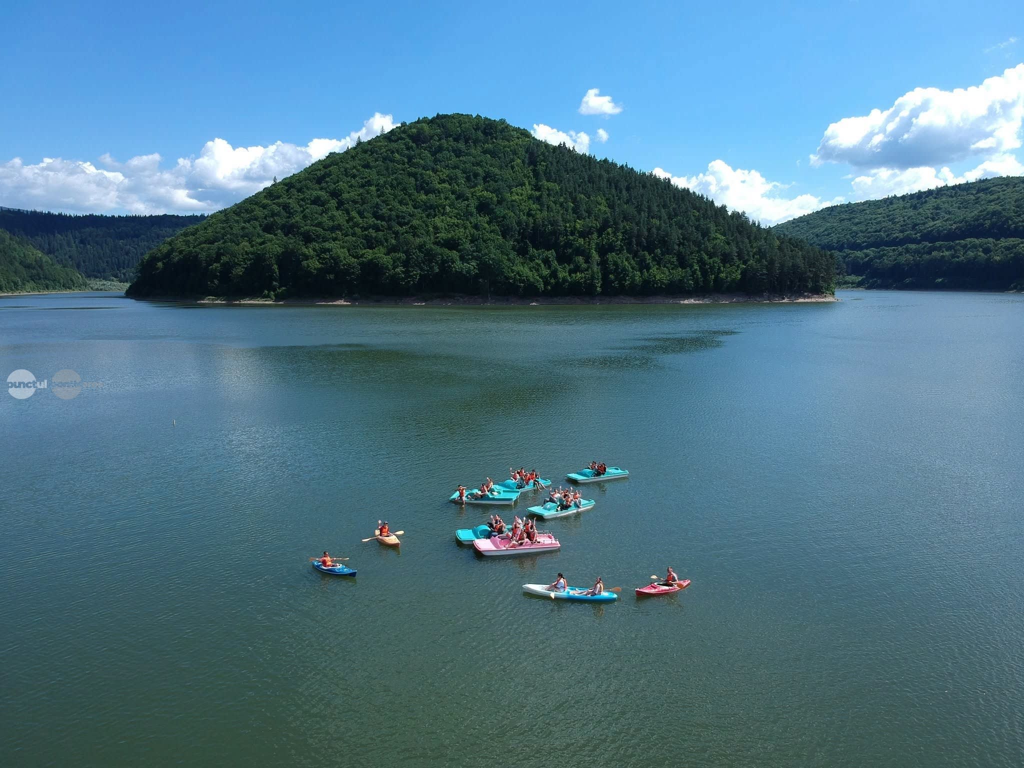 Participanți plimbându-se cu caiacul pe lac în timpul nopții, sub cerul înstelat Participanți plimbându-se cu caiacul pe lac în timpul nopții, sub cerul înstelat