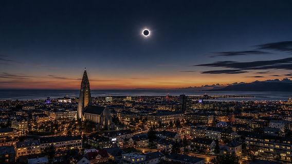 Reykjavik, capitala Islandei, cu cer senin și oameni privind eclipsa Reykjavik, capitala Islandei, cu cer senin și oameni privind eclipsa