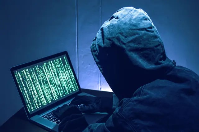 Hacker în fața unui calculator, simbolizând atac cibernetic asupra sistemului educațional francez Hacker în fața unui calculator, simbolizând atac cibernetic asupra sistemului educațional francez
