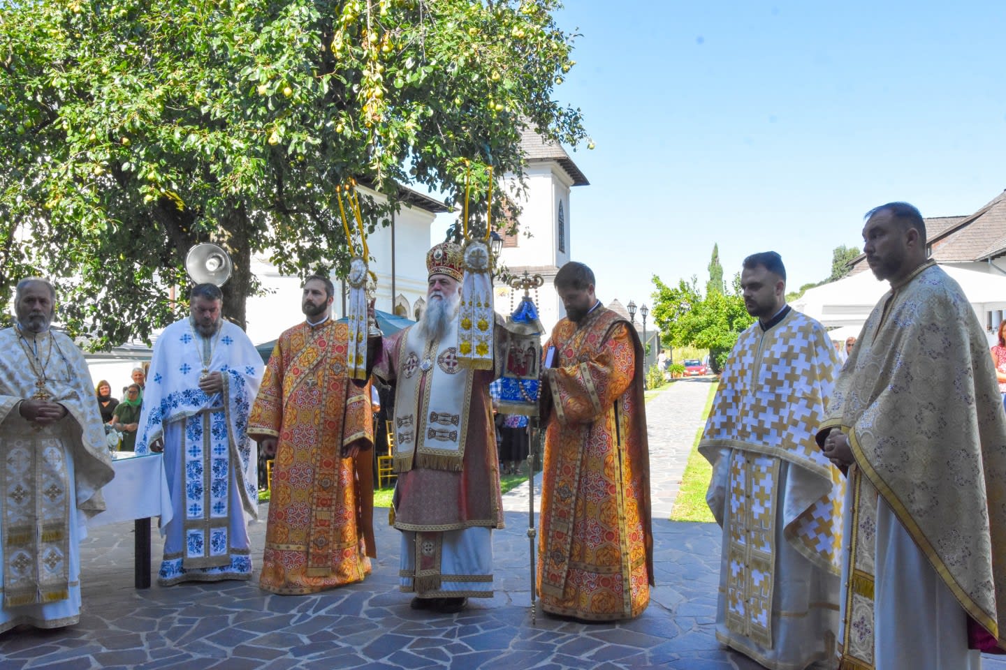 Preot în biserică cu iconostas și credincioși în rugăciune Preot în biserică cu iconostas și credincioși în rugăciune