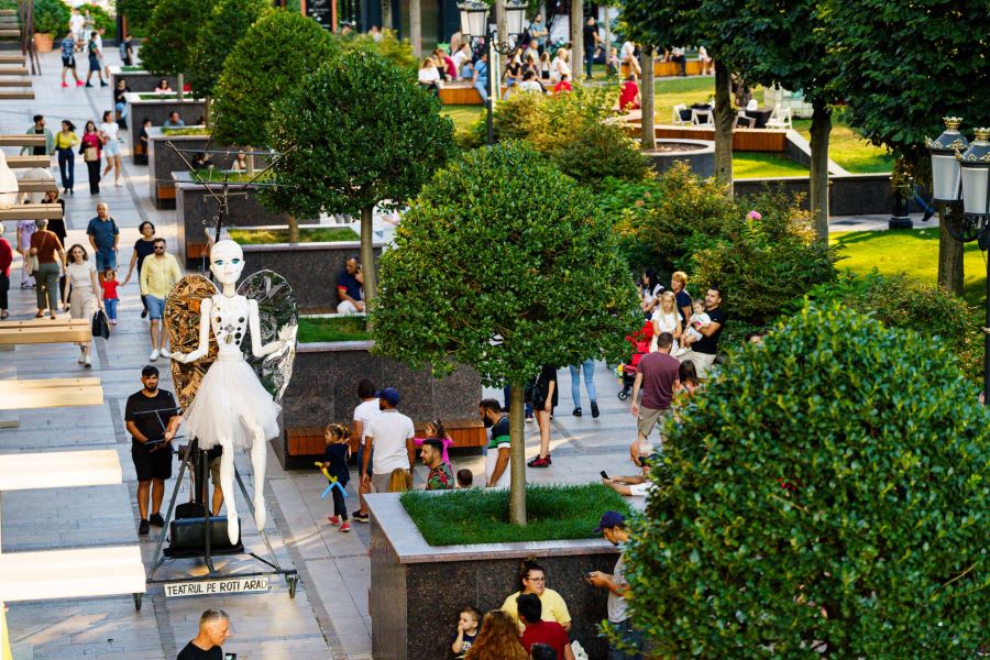 Tineri în parc urban modern, spații verzi și clădiri moderne în Constanța