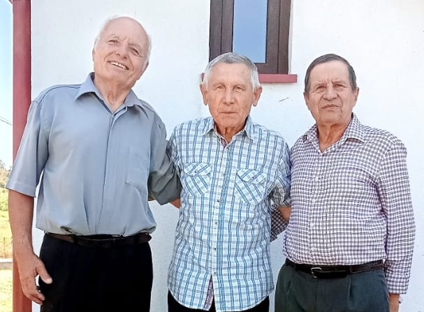 Trei profesori în vârstă zâmbind, în timpul unei petreceri de rămas-bun Trei profesori în vârstă zâmbind, în timpul unei petreceri de rămas-bun