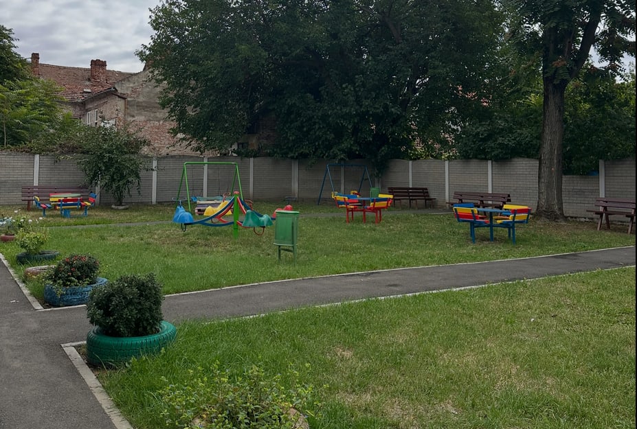 Echipe de muncitori recondiționând mobilier de joacă în curtea unei grădinițe Echipe de muncitori recondiționând mobilier de joacă în curtea unei grădinițe