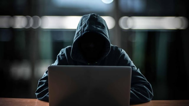 Hacker în fața calculatorului, simboluri cibernetice și coduri digitale