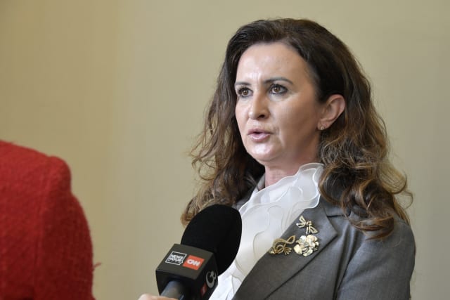 Natalia Intotero în birou, cu Porsche și Harley-Davidson în fundal