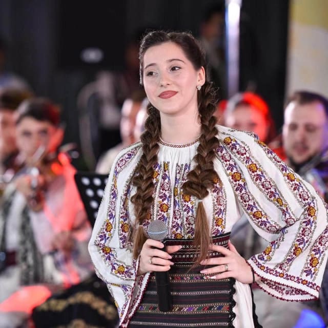 tânără interpretă de muzică populară pe scenă