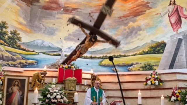 cruce de lemn căzută peste preot în biserică