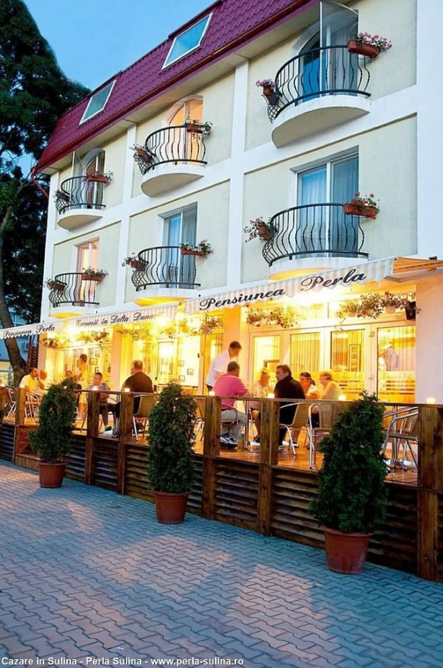terasa pensiunii cu muzică live și turiști relaxați
