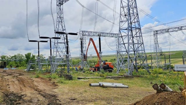 Stâlp electric și cabluri în zonă rurală